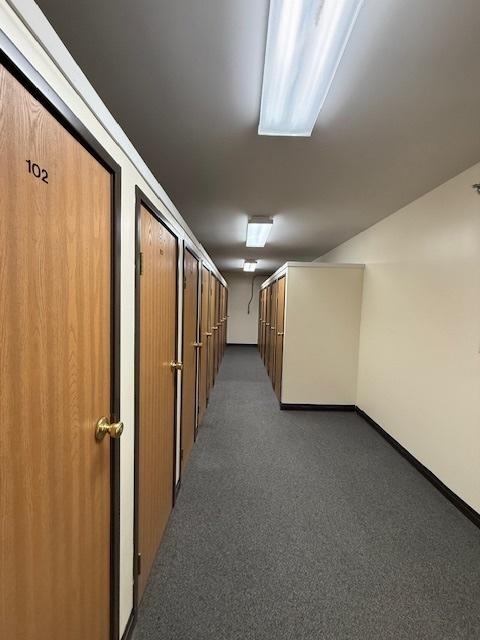 hallway with dark colored carpet