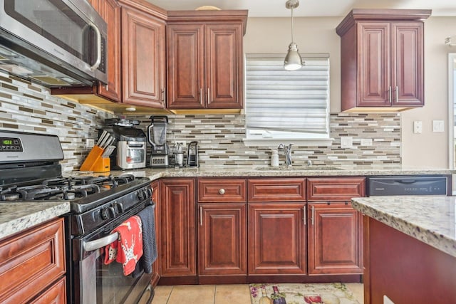 kitchen with decorative backsplash, sink, light stone countertops, and appliances with stainless steel finishes