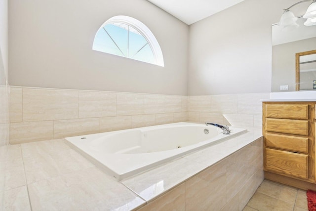 bathroom with tile patterned floors, tiled tub, and vanity