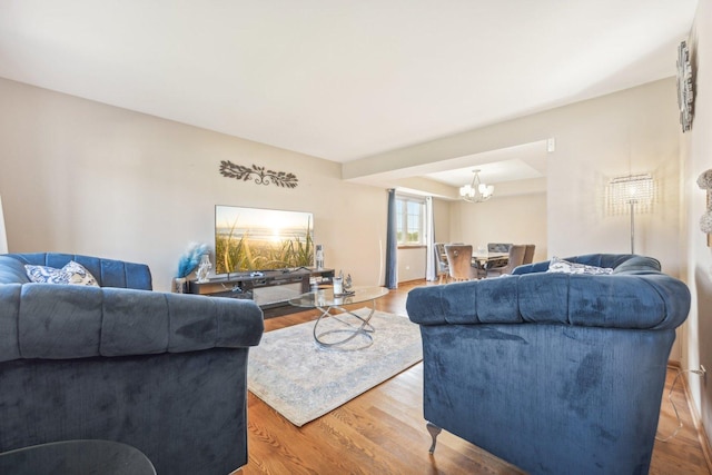 living room with hardwood / wood-style flooring and a notable chandelier