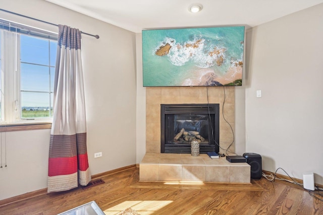 interior space featuring a tile fireplace and hardwood / wood-style flooring