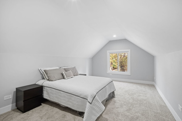 bedroom featuring light carpet and lofted ceiling