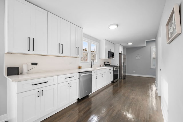 kitchen featuring stainless steel appliances, white cabinetry, dark hardwood / wood-style floors, and light stone counters