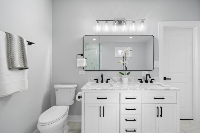 bathroom featuring vanity, toilet, and a shower with door