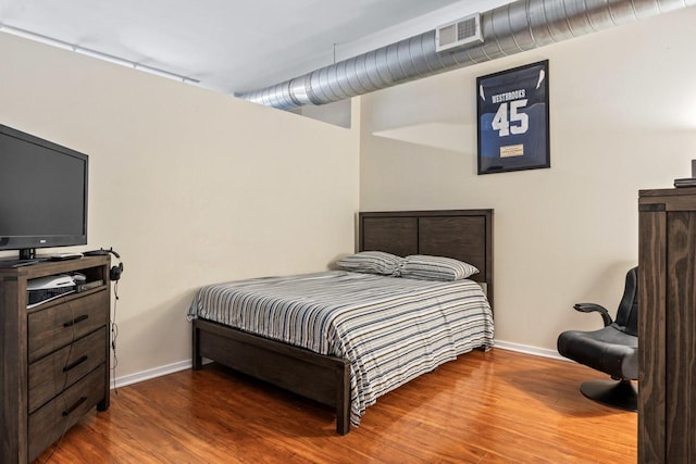 bedroom with dark hardwood / wood-style flooring