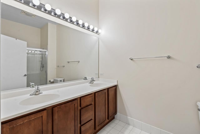 bathroom featuring tile patterned floors, vanity, an enclosed shower, and toilet