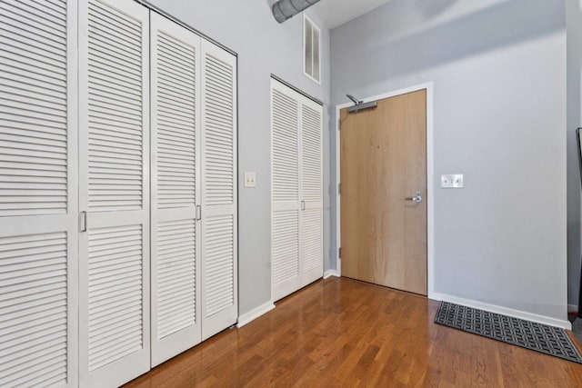 interior space featuring wood-type flooring and two closets