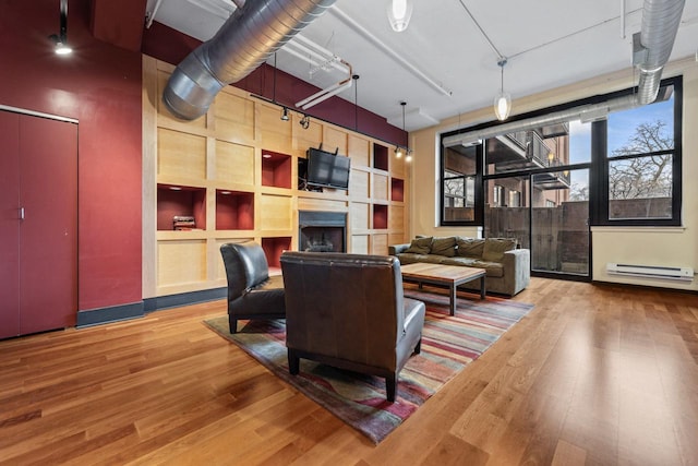 living room featuring light hardwood / wood-style floors and a baseboard heating unit