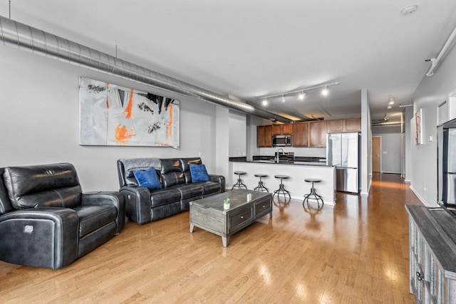 living room with sink and light hardwood / wood-style floors