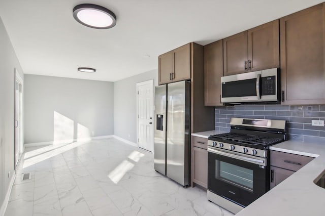 kitchen with appliances with stainless steel finishes and tasteful backsplash