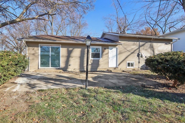 back of property with a yard and a patio