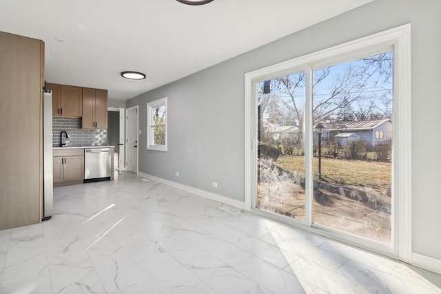 interior space featuring tasteful backsplash, sink, and appliances with stainless steel finishes