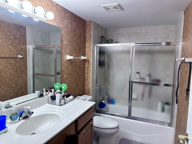 full bathroom with tile patterned floors, vanity, toilet, and shower / bath combination with glass door