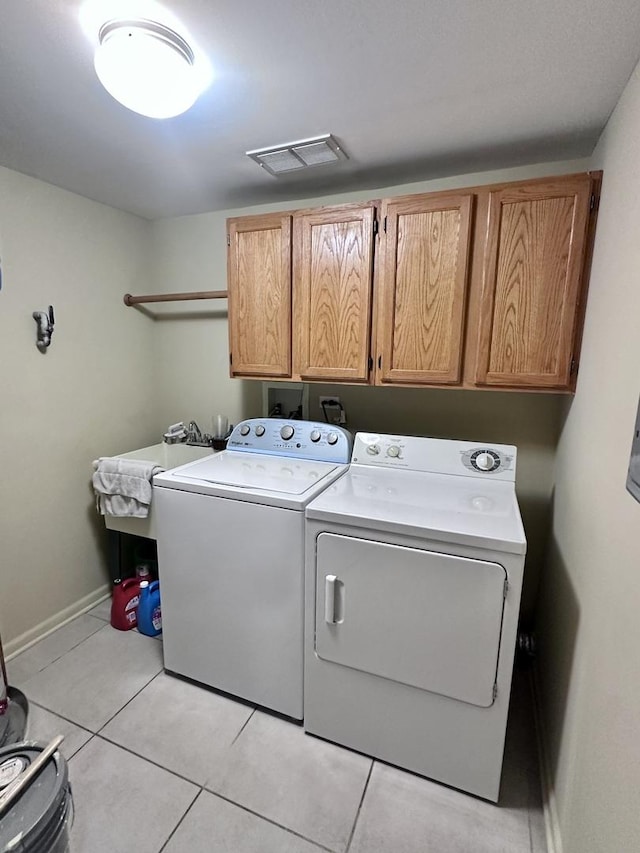 laundry room featuring cabinets, light tile patterned floors, separate washer and dryer, and sink