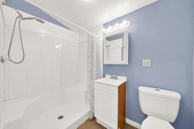 bathroom with tile patterned floors, toilet, vanity, and walk in shower