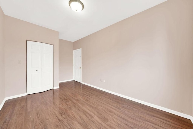 unfurnished bedroom featuring a closet and dark hardwood / wood-style floors