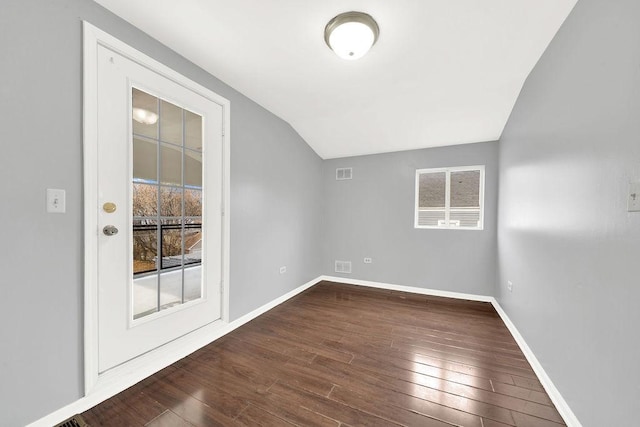 empty room with dark wood-type flooring and vaulted ceiling