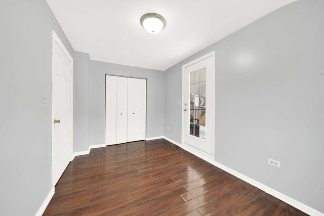 unfurnished bedroom with dark hardwood / wood-style flooring and a closet