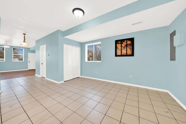 tiled spare room with ceiling fan