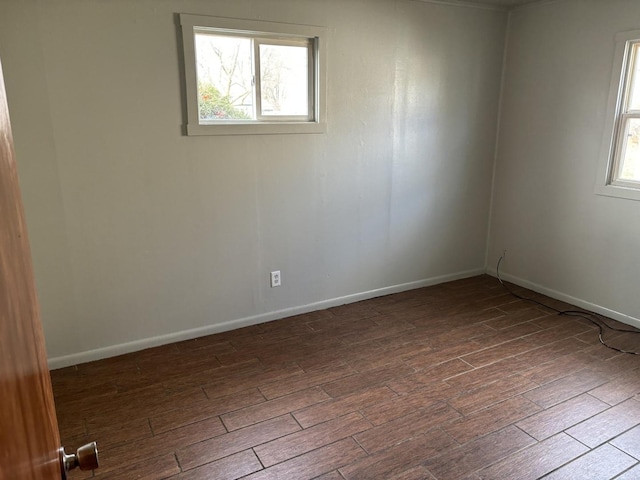 unfurnished room with dark hardwood / wood-style floors and a wealth of natural light