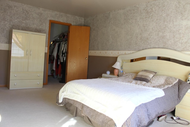 bedroom featuring carpet, a spacious closet, and a closet