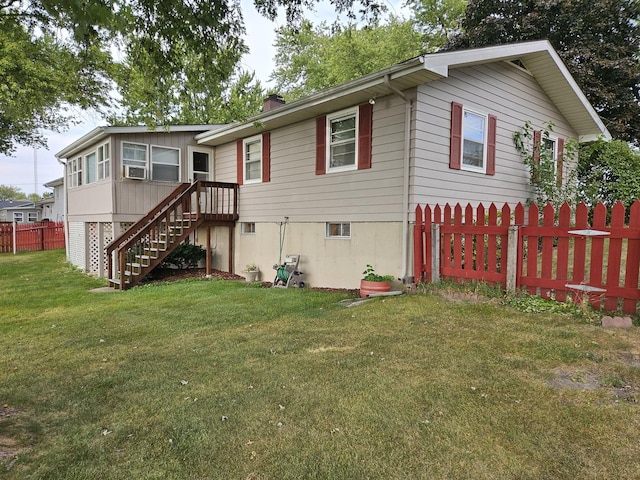 rear view of property featuring a lawn and cooling unit