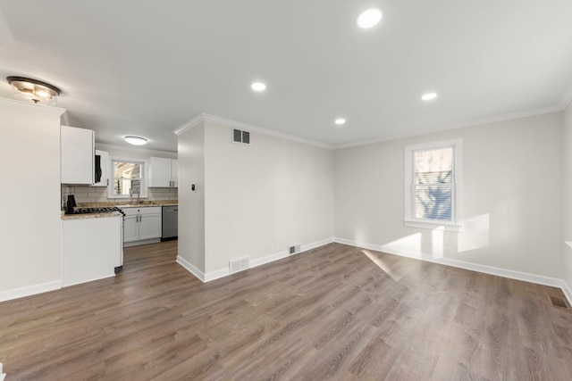 unfurnished living room featuring sink, crown molding, and light hardwood / wood-style floors