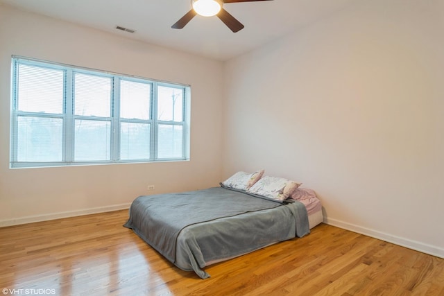 bedroom with light hardwood / wood-style floors and ceiling fan