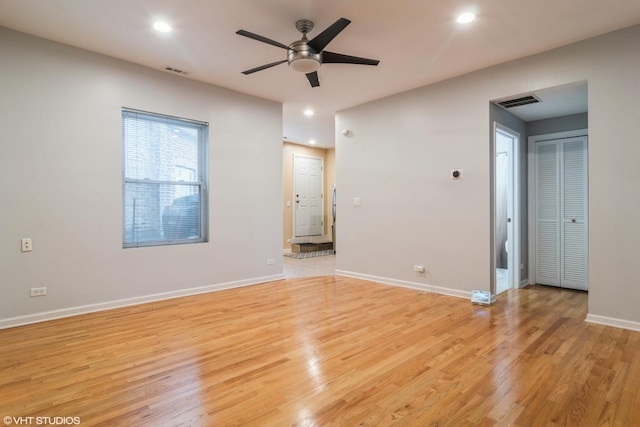 empty room with ceiling fan and light hardwood / wood-style flooring