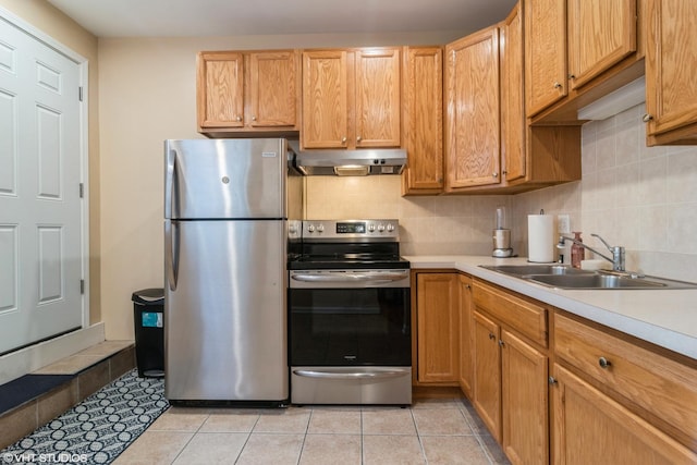 kitchen featuring appliances with stainless steel finishes, backsplash, light tile patterned floors, and sink