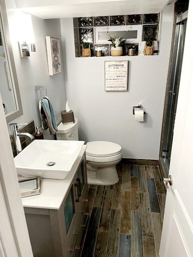 bathroom with toilet, wood-type flooring, and sink