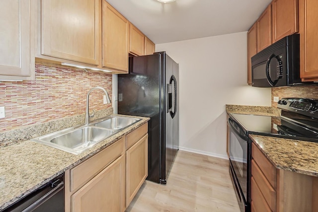 kitchen with backsplash, sink, black appliances, and light wood-type flooring