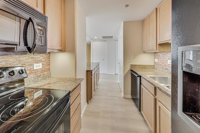 kitchen with light brown cabinets, tasteful backsplash, light stone counters, and black appliances