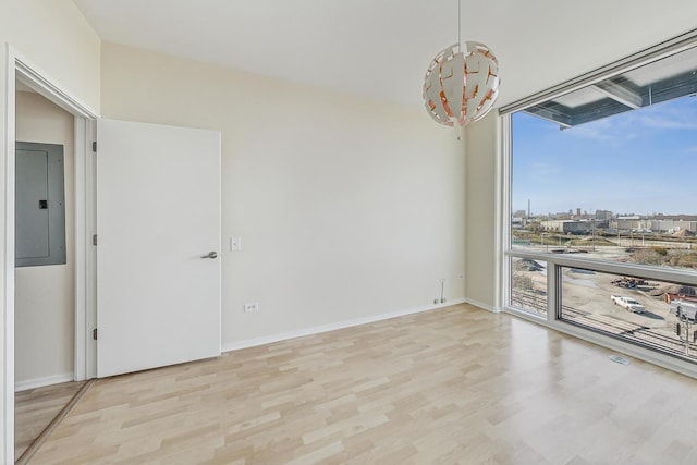 spare room with light hardwood / wood-style floors and electric panel