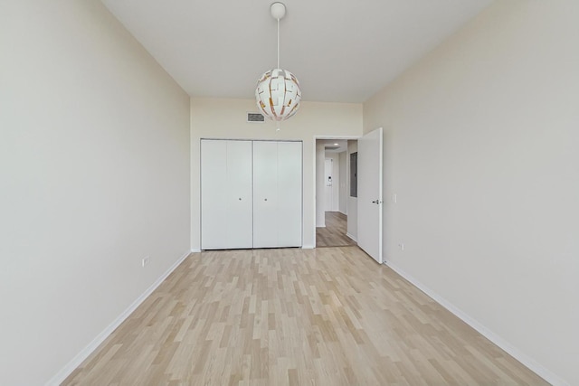 unfurnished bedroom with light hardwood / wood-style floors and a closet