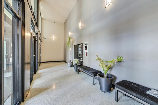 corridor featuring a towering ceiling