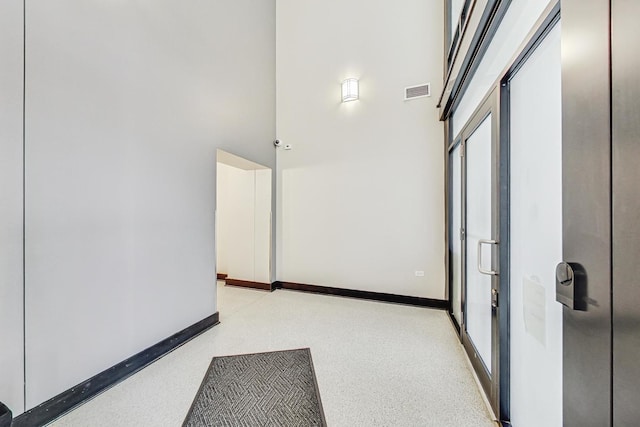 hall featuring a towering ceiling