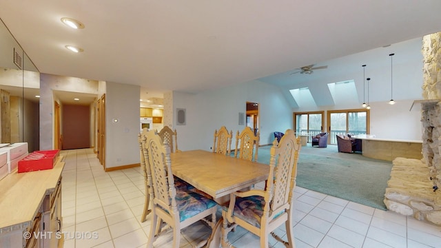 dining room with a skylight, ceiling fan, and light tile patterned floors