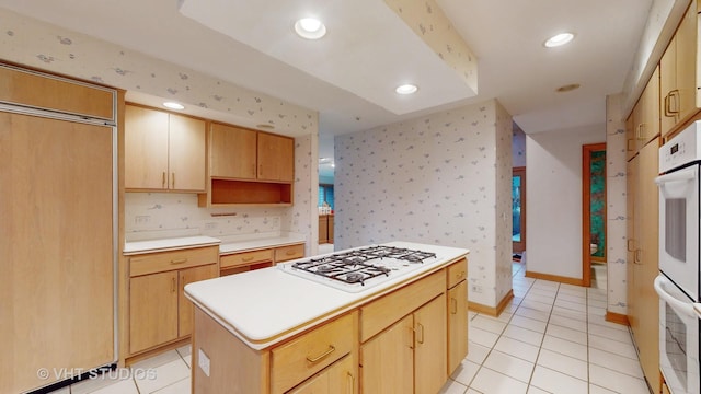 kitchen with light tile patterned floors, a center island, white gas cooktop, and light brown cabinets