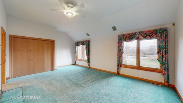 unfurnished bedroom with ceiling fan, a closet, carpet floors, and lofted ceiling