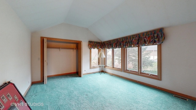 unfurnished bedroom with light carpet, vaulted ceiling, and a closet