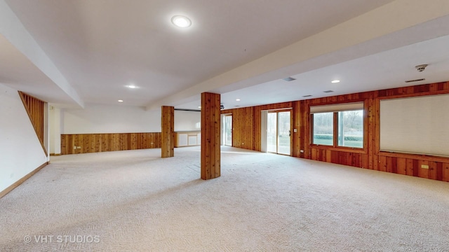 interior space featuring wooden walls and light colored carpet