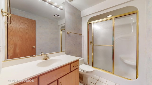 bathroom with toilet, vanity, tile patterned floors, and an enclosed shower