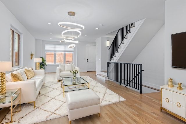 living room featuring a chandelier and light hardwood / wood-style flooring