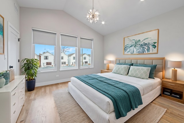 bedroom featuring an inviting chandelier, vaulted ceiling, and light wood-type flooring