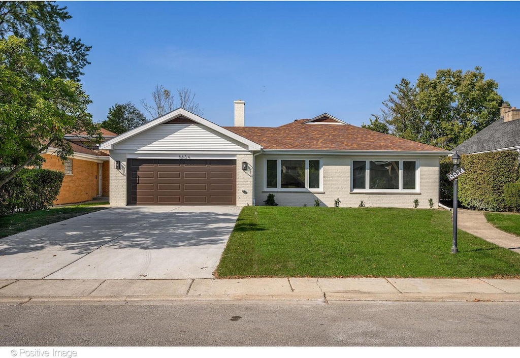 single story home with a garage and a front lawn