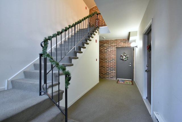 staircase featuring baseboard heating and carpet