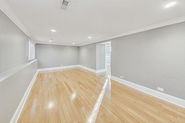 spare room featuring light hardwood / wood-style floors and ornamental molding