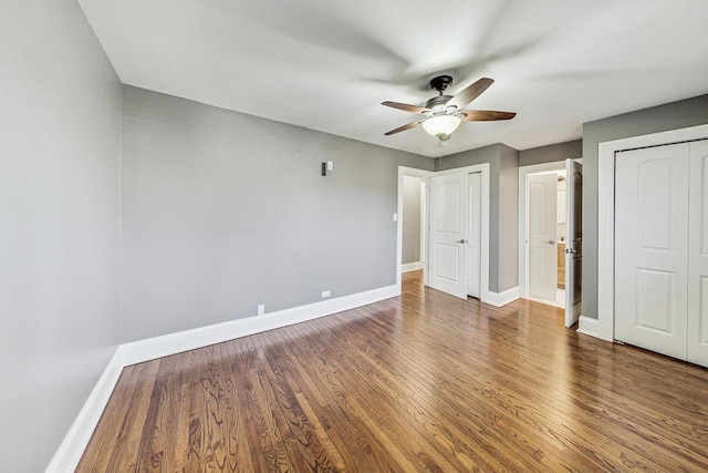 unfurnished bedroom featuring ceiling fan and dark wood-type flooring