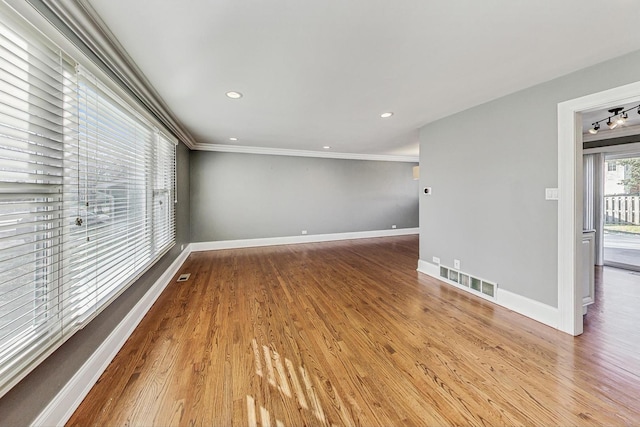 empty room with hardwood / wood-style floors and ornamental molding